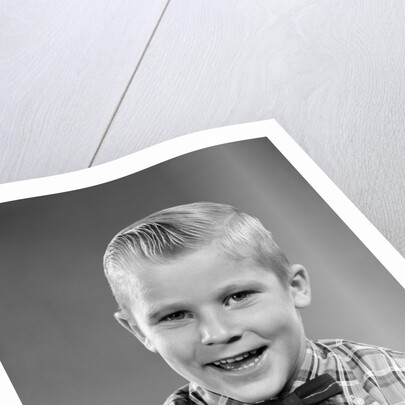 1950s smiling blond boy wearing plaid shirt bow ties looking at camera by Anonymous