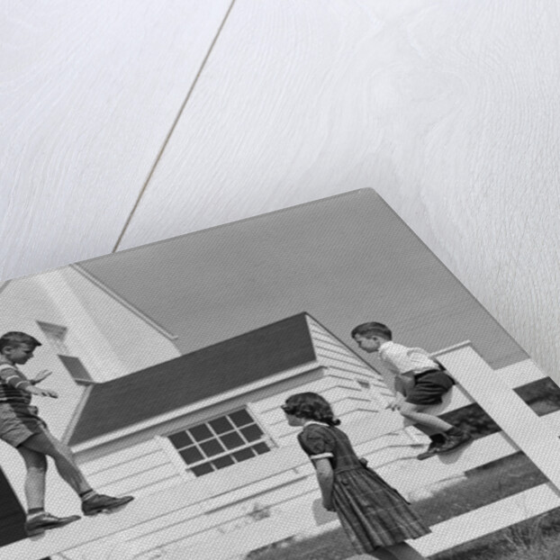 1950s boy walking balancing on fence other children standing sitting next to fence by Anonymous