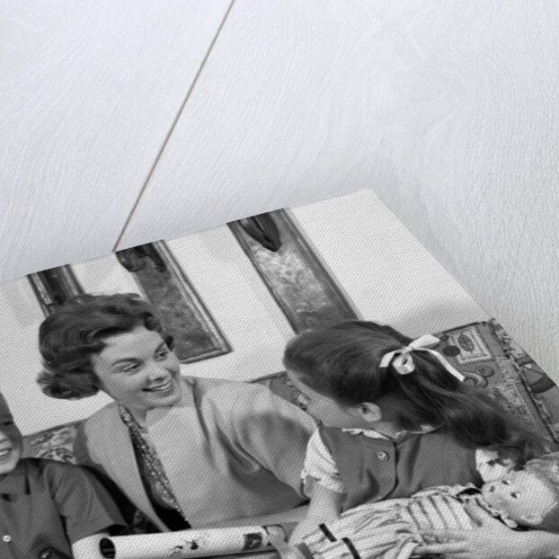 1960s mother sitting on couch with son and daughter by Anonymous