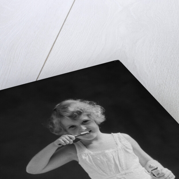1930s child curly hair blond girl brushing teeth toothbrush looking at camera by Anonymous