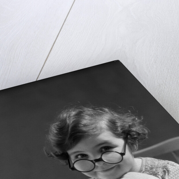 1930s portrait little girl smiling wearing big round eyeglasses looking at camera by Anonymous