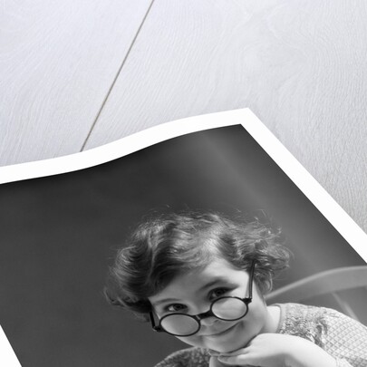1930s portrait little girl smiling wearing big round eyeglasses looking at camera by Anonymous