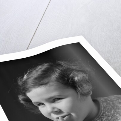 1930s little girl with finger to lips making quiet gesture looking at camera by Anonymous