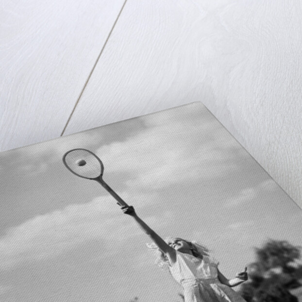 1930s girl playing tennis jumping to hit ball overhead by Anonymous