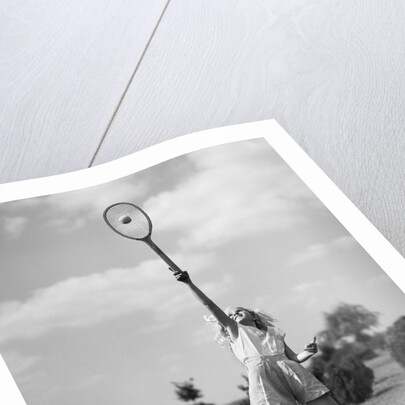 1930s girl playing tennis jumping to hit ball overhead by Anonymous