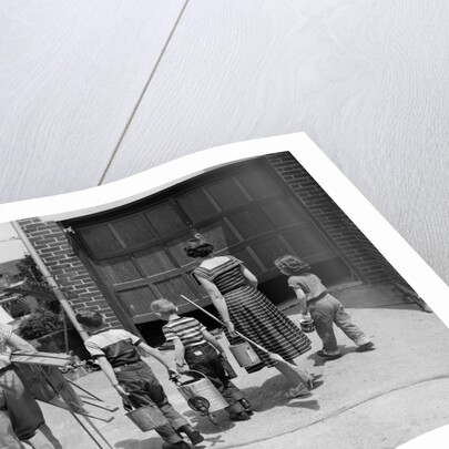 1950s family mother father 3 children from behind carrying gardening home improvement tools equipment by Anonymous