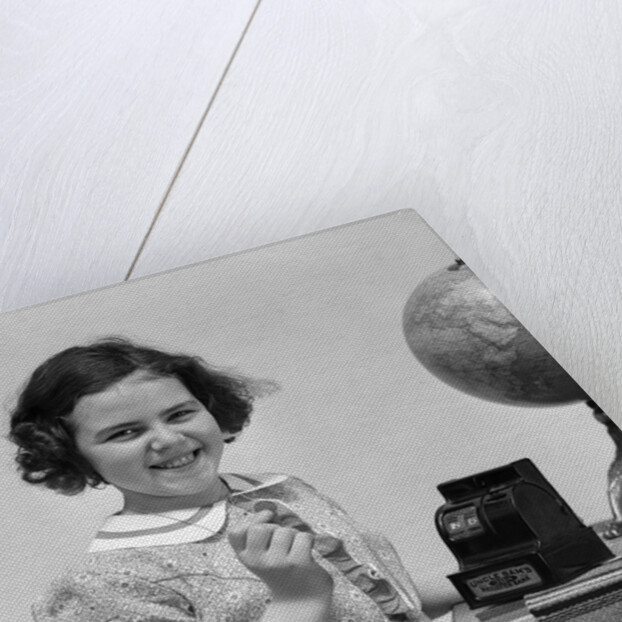 1930s child smiling girl putting money coin into toy cash register bank by Anonymous