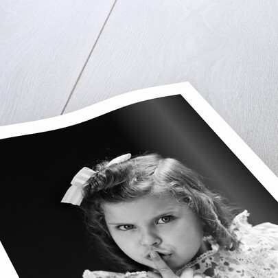 1950s child serious little girl pressing finger to lips hush be quiet secret by Anonymous