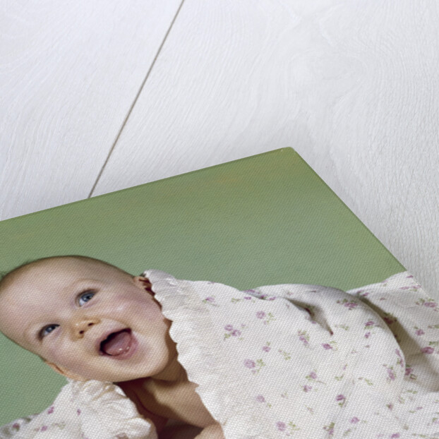 1960s smiling happy baby peeking out from under a blanket by Anonymous