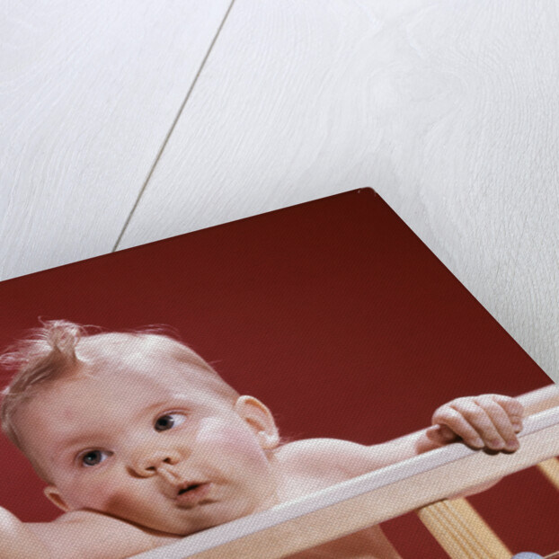 1960s baby reaching out from crib by Anonymous