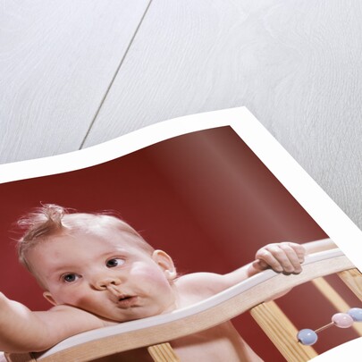 1960s baby reaching out from crib by Anonymous