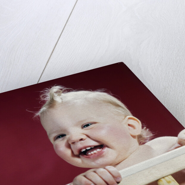 1960s laughing blond baby in crib or playpen by Anonymous