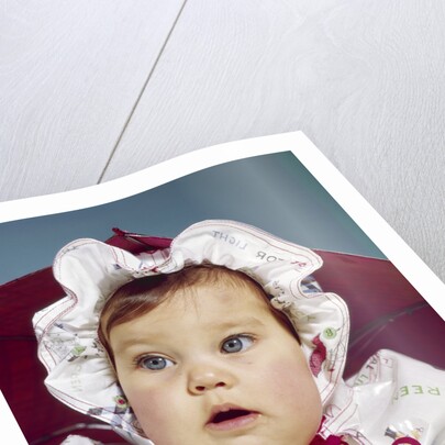 1960s baby wearing raincoat and hat by Anonymous