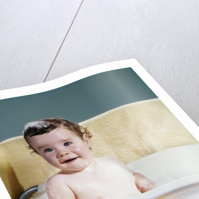 1960s smiling baby in bath looking at camera by Anonymous