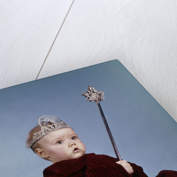 1960s baby girl wearing rhinestone tiara and red velvet cloak holding scepter by Anonymous