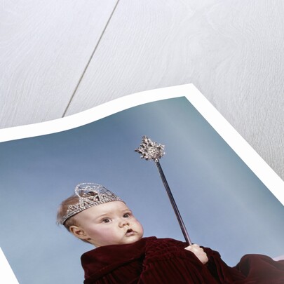 1960s baby girl wearing rhinestone tiara and red velvet cloak holding scepter by Anonymous