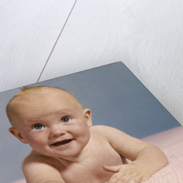 1970s smiling happy baby crawling straight ahead on pink blanket looking at camera by Anonymous