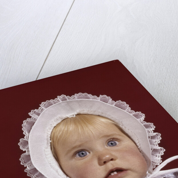 1960s portrait baby girl wearing bonnet and blue gingham dress showing two front teeth looking at camera by Anonymous