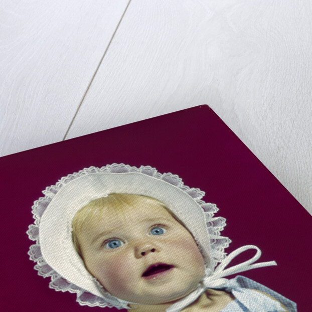 1960s blonde baby blue eyes wearing ruffled bonnet facial expression of wonder looking at camera by Anonymous