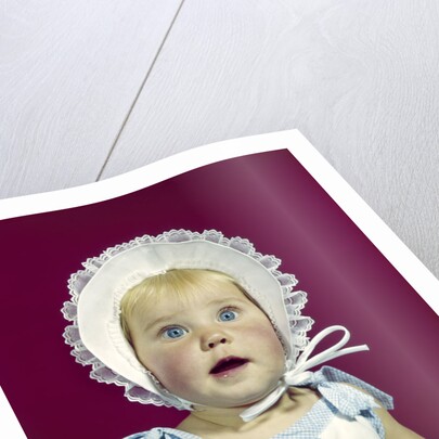 1960s blonde baby blue eyes wearing ruffled bonnet facial expression of wonder looking at camera by Anonymous