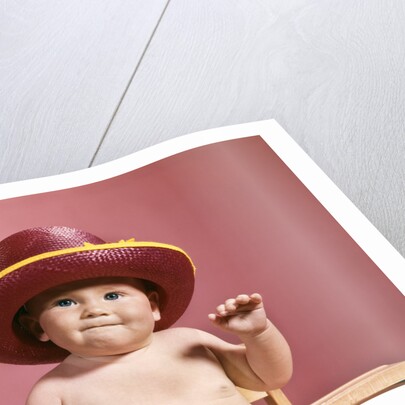 1960s baby making face wearing red straw hat by Anonymous