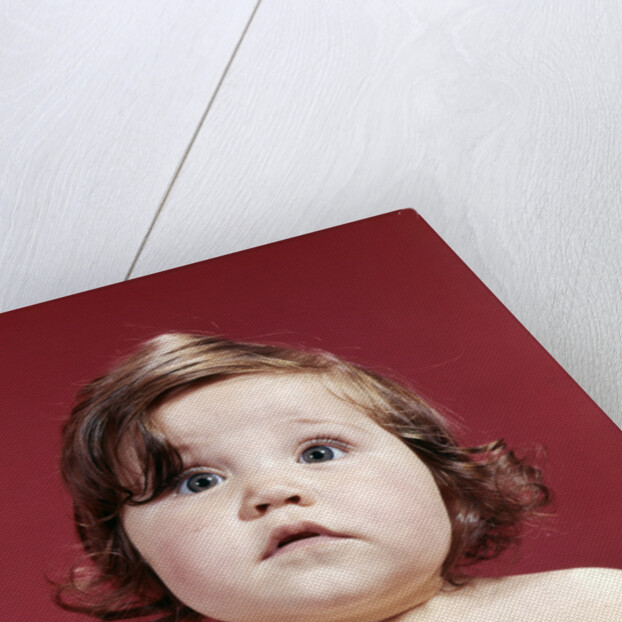 1960s portrait brunette baby girl with chubby round face uncertain facial expression looking at camera by Anonymous