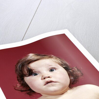 1960s portrait brunette baby girl with chubby round face uncertain facial expression looking at camera by Anonymous