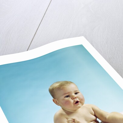1960s baby sitting holding on to his feet by Anonymous