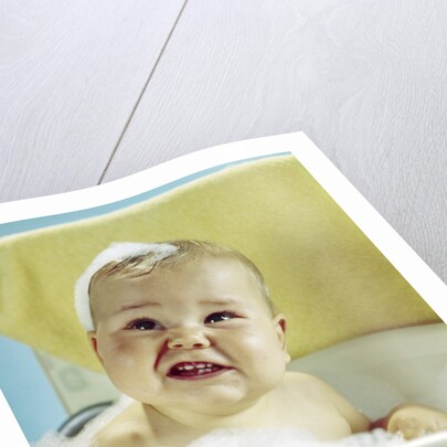 1960s smiling baby in bath looking up by Anonymous