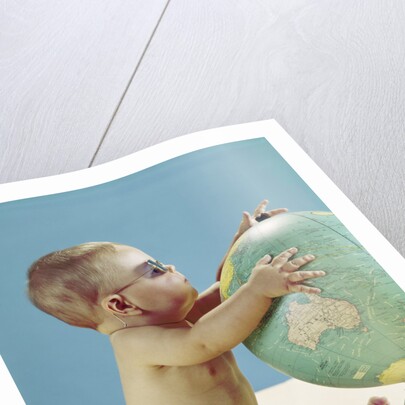 1960s baby wearing eyeglasses hugging the world globe earth by Anonymous
