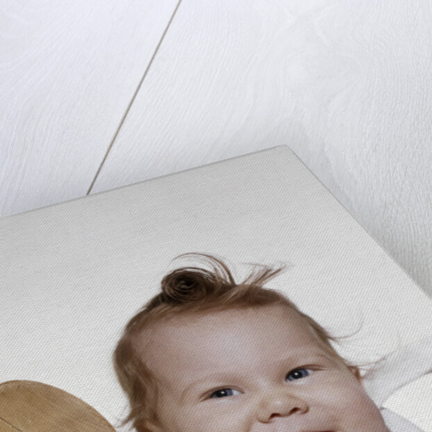 1960s 1970s smiling baby wearing bib and holding wooden spoon by Anonymous