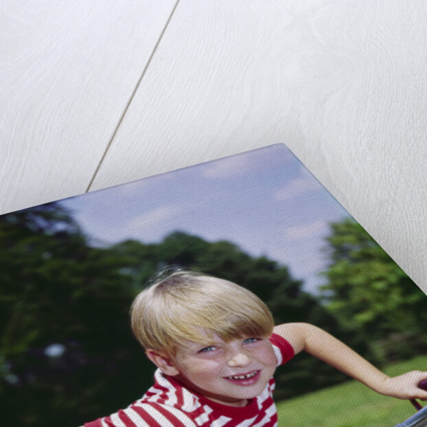 1970s 1960s smiling blond boy leaning over handlebars of bicycle looking at camera by Anonymous