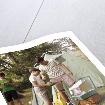 1960s three boys at campsite cooking camp stove eating food tent teens by Anonymous