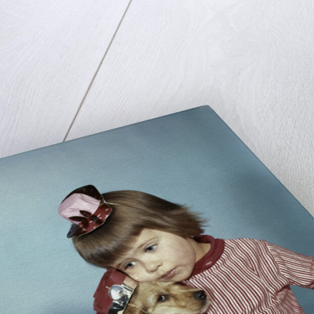 1950s 1960s little girl wearing party hat frowning hugging a cocker spaniel puppy by Anonymous