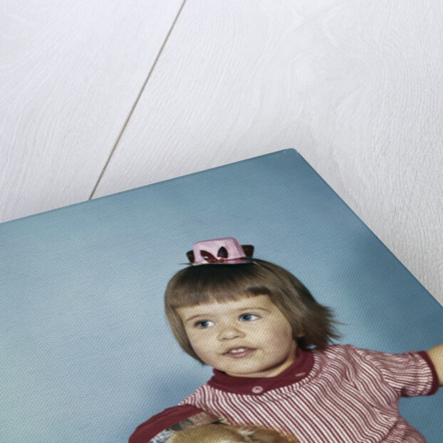 1950s 1960s little girl in party hat sitting holding a cocker spaniel puppy by Anonymous