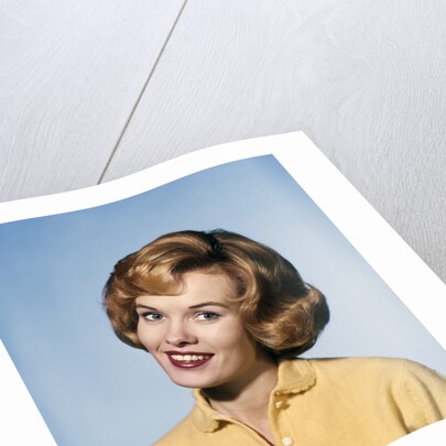 1960s smiling blond woman wearing a yellow sweater head tilted quizzical expression by Anonymous
