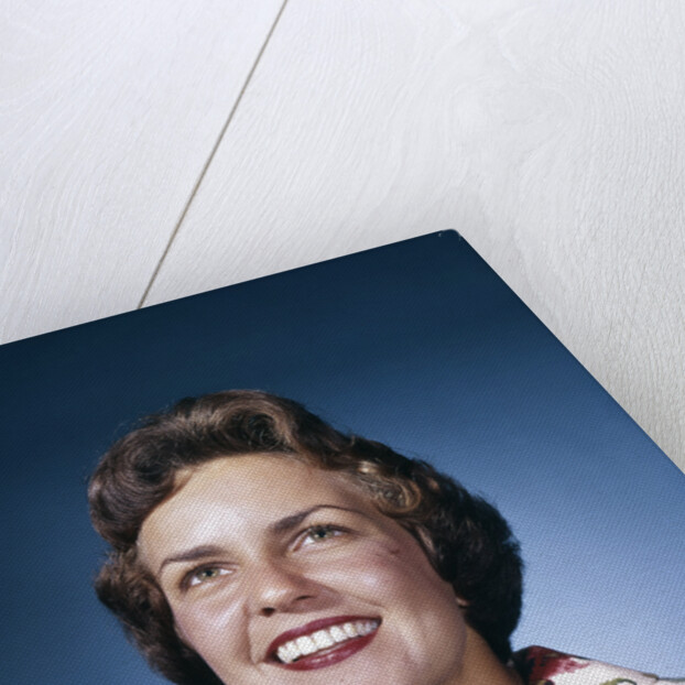 1960s smiling woman in white print dress looking up studio by Anonymous