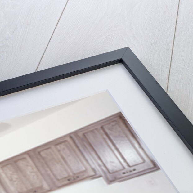 1970s kitchen with dark wooden cabinets and a microwave oven over the stove by Anonymous