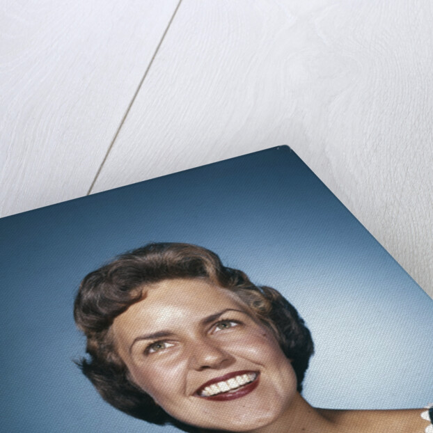 1960s smiling brunette woman in print dress looking up by Anonymous