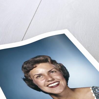 1960s smiling brunette woman in print dress looking up by Anonymous