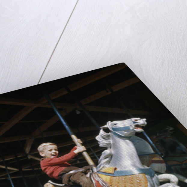 1950s excited boy riding carved wooden carousel merry-go-round horse by Anonymous