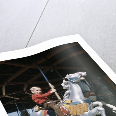 1950s excited boy riding carved wooden carousel merry-go-round horse by Anonymous