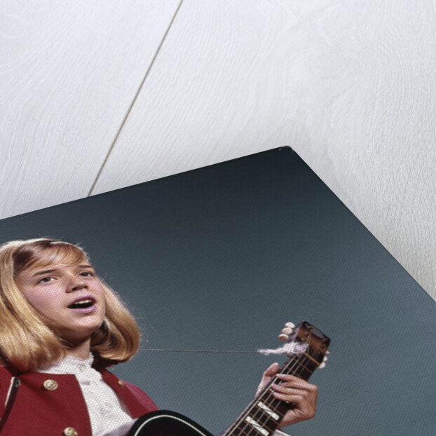 1960s blond teenaged girl singing and playing acoustic guitar by Anonymous