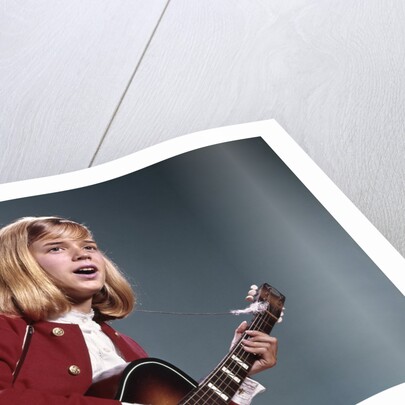 1960s blond teenaged girl singing and playing acoustic guitar by Anonymous