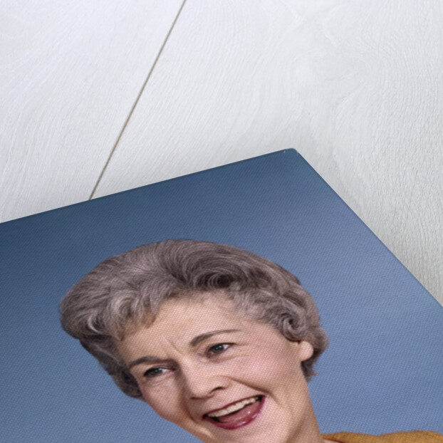1960s portrait smiling elderly woman wearing orange top laughing looking to side by Anonymous