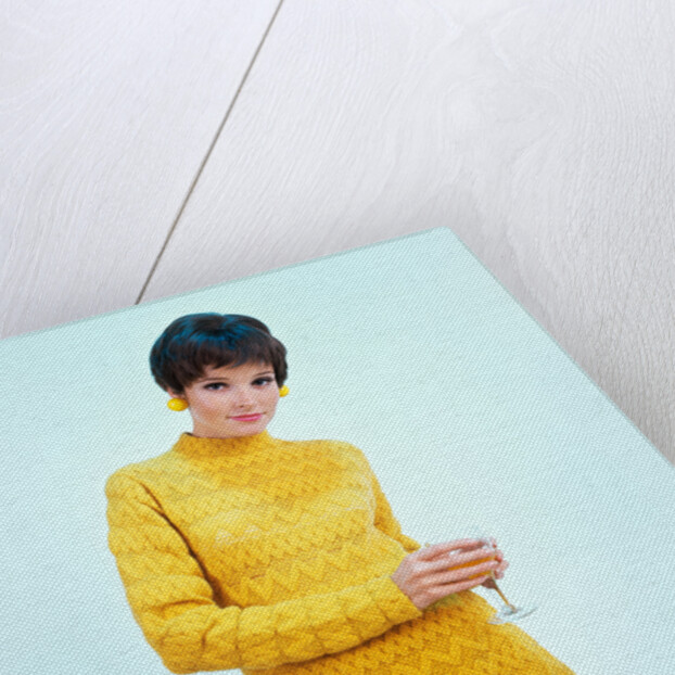 1960s brunette woman short pixie hair style yellow knit sweater earrings holding wine glass by Anonymous