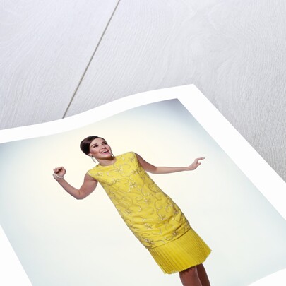 1960s smiling brunette woman modeling yellow sequined cocktail dress clothes by Anonymous