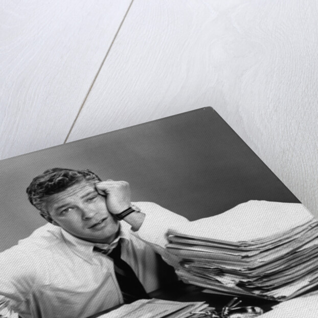 1950s portrait man overworked with desk full of papers by Anonymous