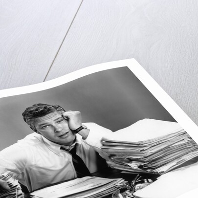 1950s portrait man overworked with desk full of papers by Anonymous