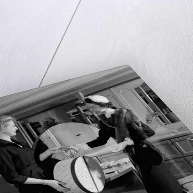 1950s woman in hat stole & gloves taking hatbox from saleswoman by Anonymous